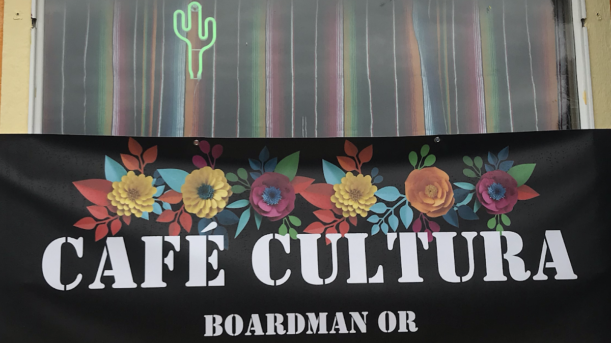 The Cafe Cultura sign with folk-art flowers and a cactus