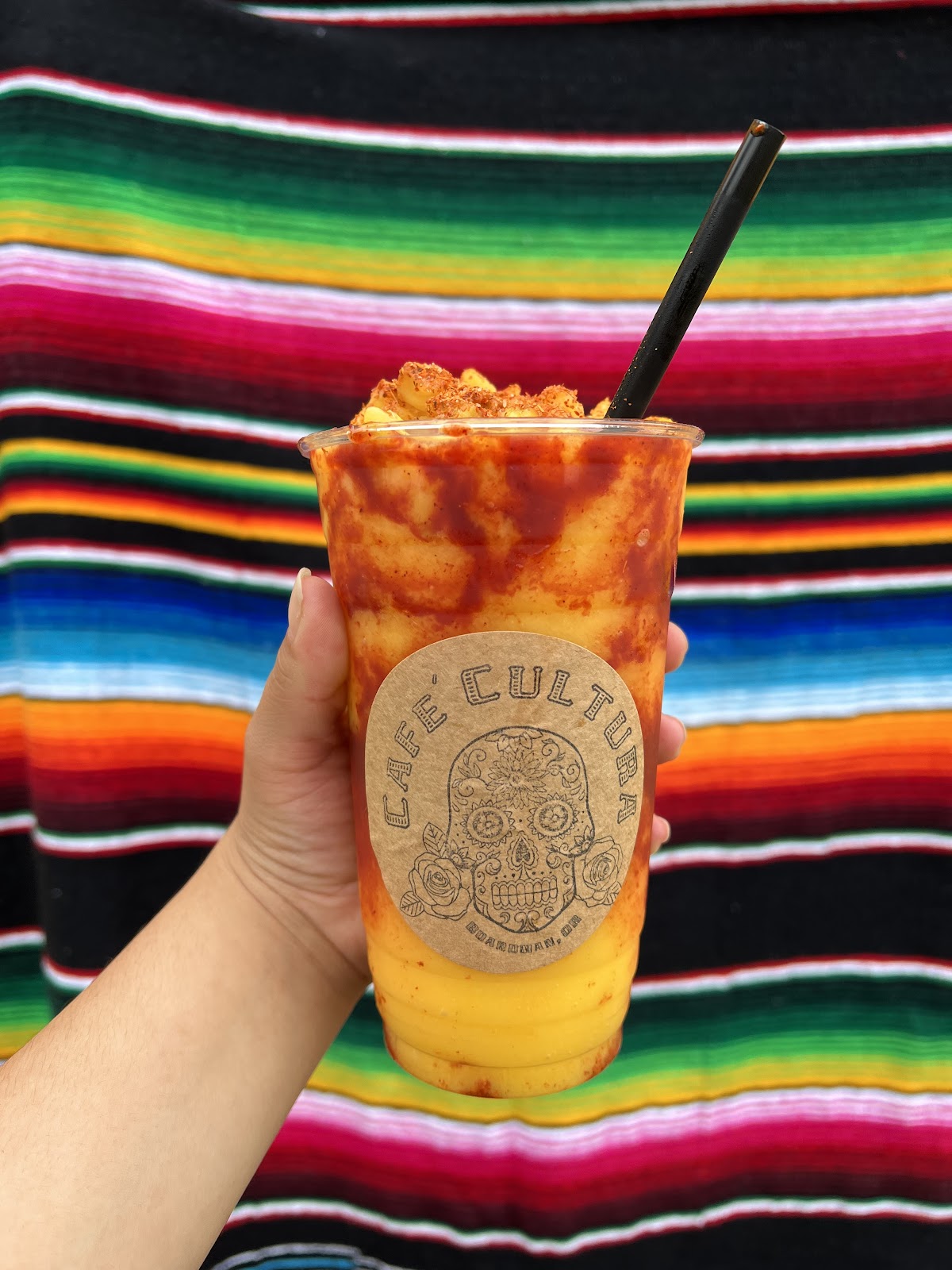 A mangonada-style drink against a bright serape blanket