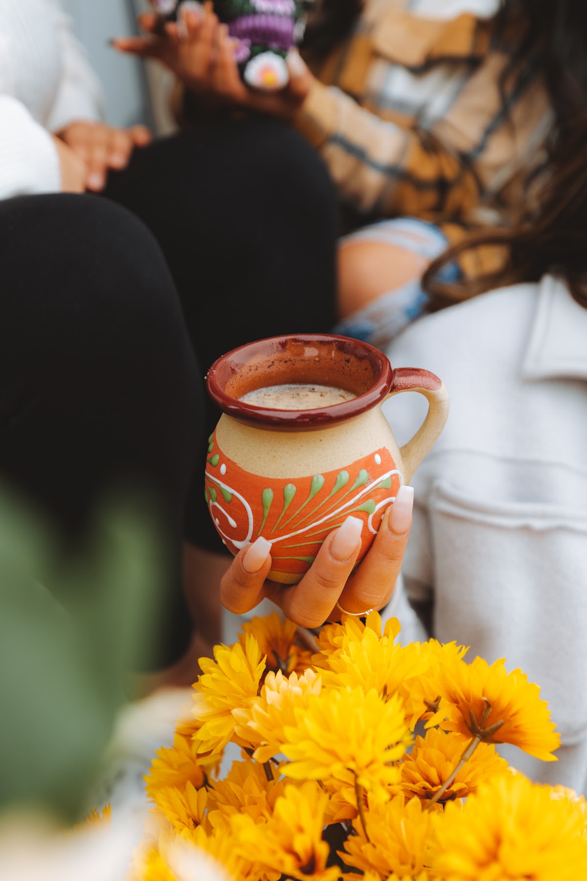 A hand-painted clay mug of café de olla shared among friends at Cafe Cultura